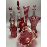 A collection of nine pieces of cranberry and ruby coloured glass, including a pair of decanters, two