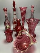 A collection of nine pieces of cranberry and ruby coloured glass, including a pair of decanters, two