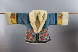 A Chinese embroidered silk winter jacket, late 19th/early 20th century, with white fur lining,