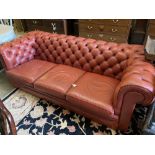 A three seater buttoned red leather chesterfield settee, length 210cm, depth 90cm, height 68cm