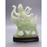 A Chinese bowenite jade group of Guanyin riding on elephant, 27cm high, wood stand
