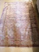 A Chinese rust ground rug, woven with a trellis pattern of scrolling foliage, 120 x 180cm