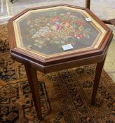 An grois point tapestry panel, inset in the top of a hexagonal mahogany table, width 54cm, depth