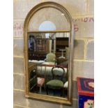 A modern gilt framed wall mirror, the arched top with an inset lacework panel, width 59cm, height