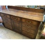 A late George III mahogany low dresser, fitted nine small drawers, about a central cupboard, width