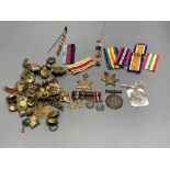 A WWII trio and a WWI pair, a collection of cap badges and non matching WWII miniatures