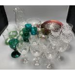 A collection of clear and coloured glassware, including four green bowled wines, vine etched
