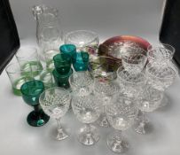 A collection of clear and coloured glassware, including four green bowled wines, vine etched