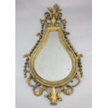 An early 19th century giltwood and gesso wall mirror, tear drop shaped with urn, flower and bell