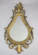 An early 19th century giltwood and gesso wall mirror, tear drop shaped with urn, flower and bell