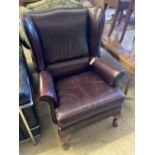 A burgundy leather wing armchair, width 74cm, depth 86cm, height 97cm