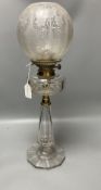 A late 19th century cut glass oil lamp with floral embossed shade, 61cm high including shade