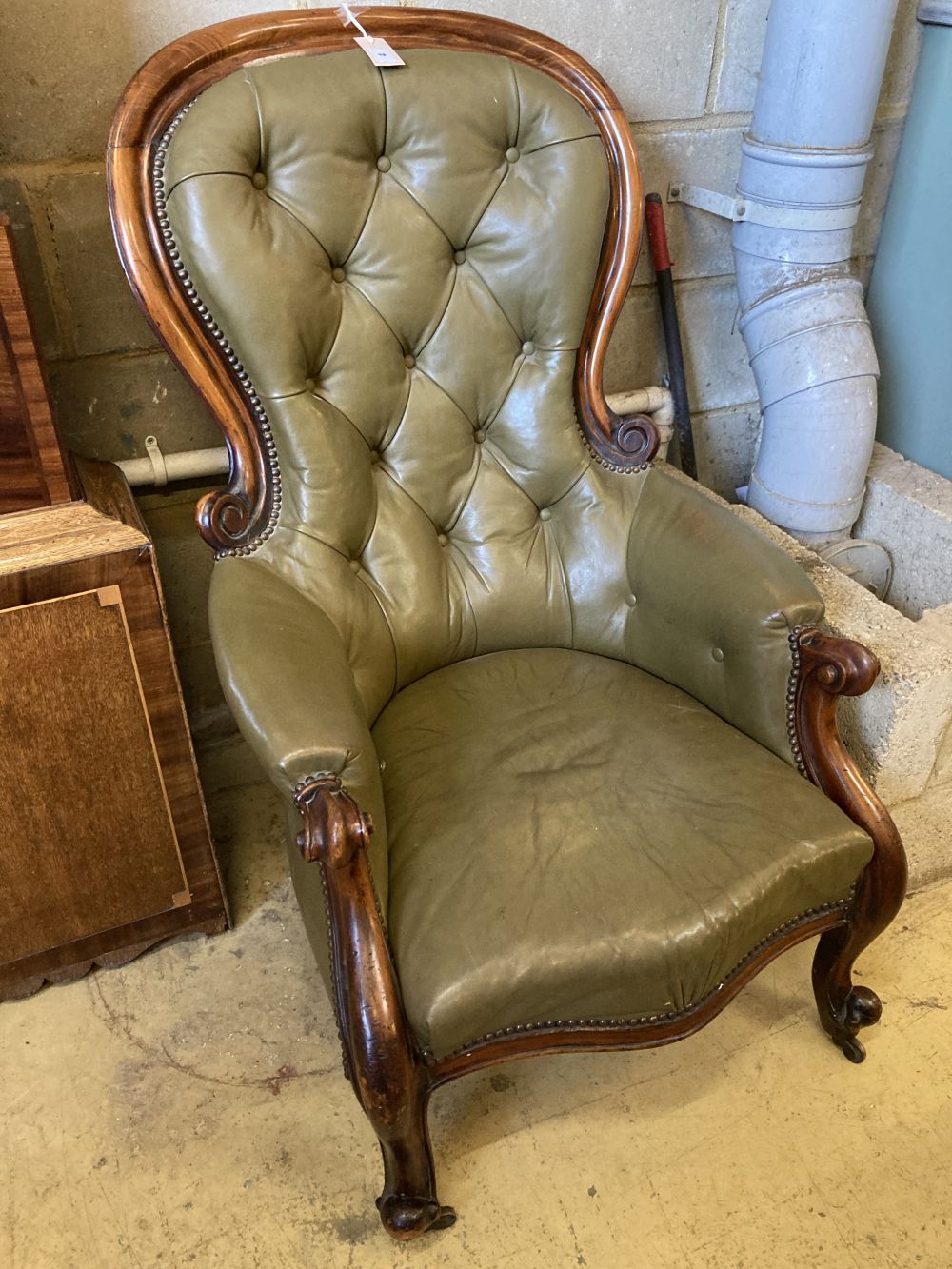 A Victorian carved and moulded showood frame spoonback armchair on scrolled legs, upholstered in