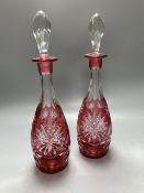 A pair of flash cut cranberry glass decanters and stoppers, height 39.5cm