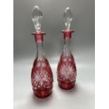 A pair of flash cut cranberry glass decanters and stoppers, height 39.5cm