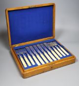 A set of twelve Victorian plated engraved carved bone handled fish knives and forks, cased