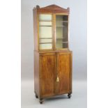 A Regency mahogany collector's cabinet, with architectural cornice and two glazed doors over two