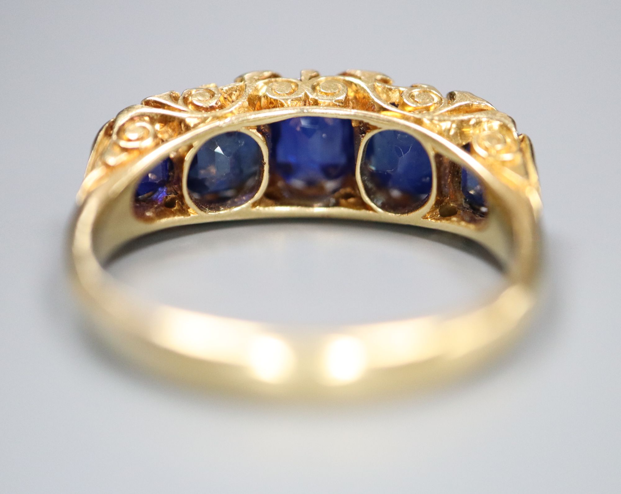 A George V 18ct gold and graduated five stone sapphire set half hoop ring, with diamond chip - Image 4 of 5