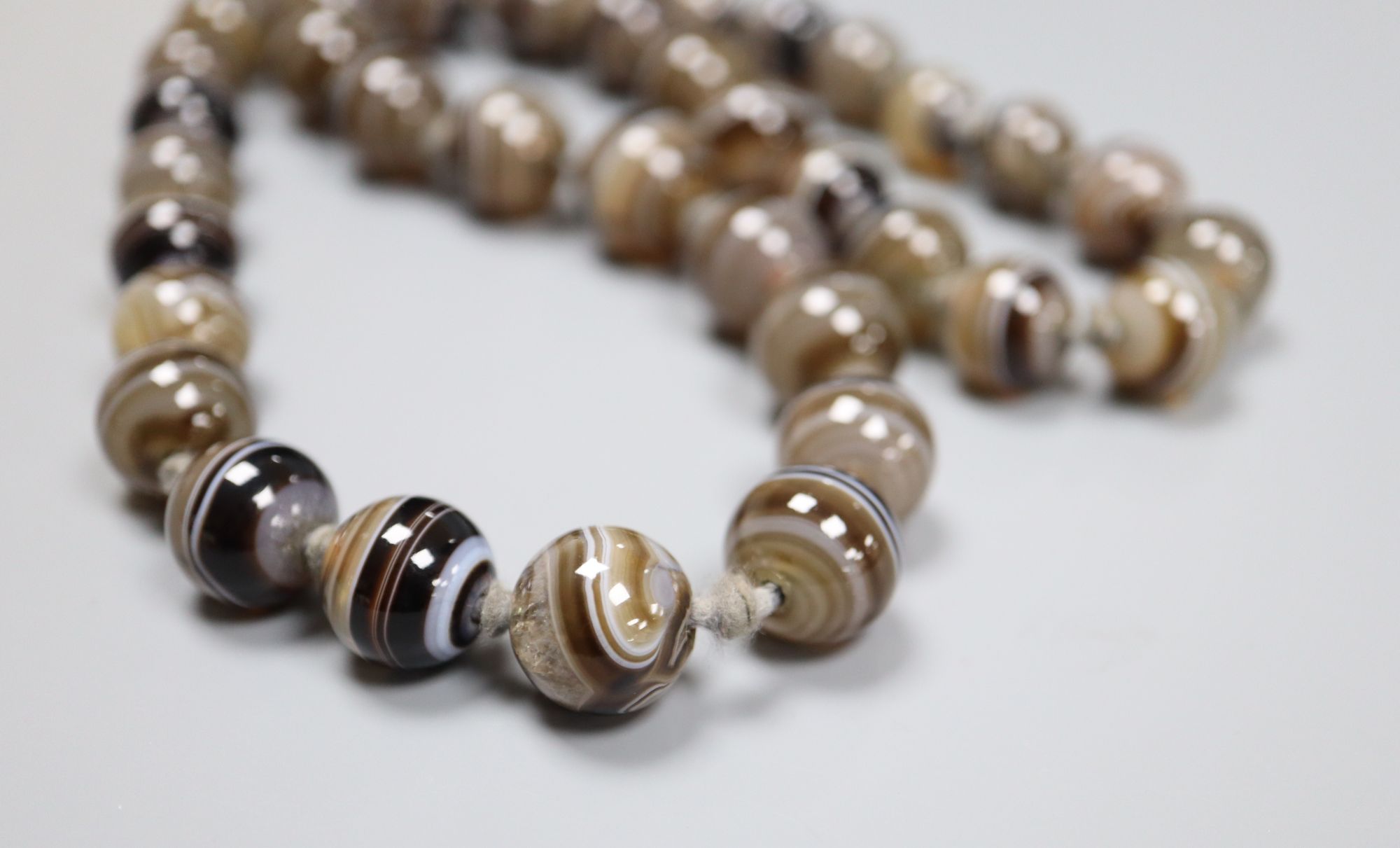 A single strand graduated banded agate bead necklace, 63cm, largest bead 15.4mm.CONDITION: The