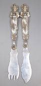 A pair of late Victorian silver fish eaters with figural handles by Goldsmiths & Silversmiths Co