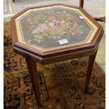 An grois point tapestry panel, inset in the top of a hexagonal mahogany table, width 54cm, depth