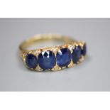 A George V 18ct gold and graduated five stone sapphire set half hoop ring, with diamond chip