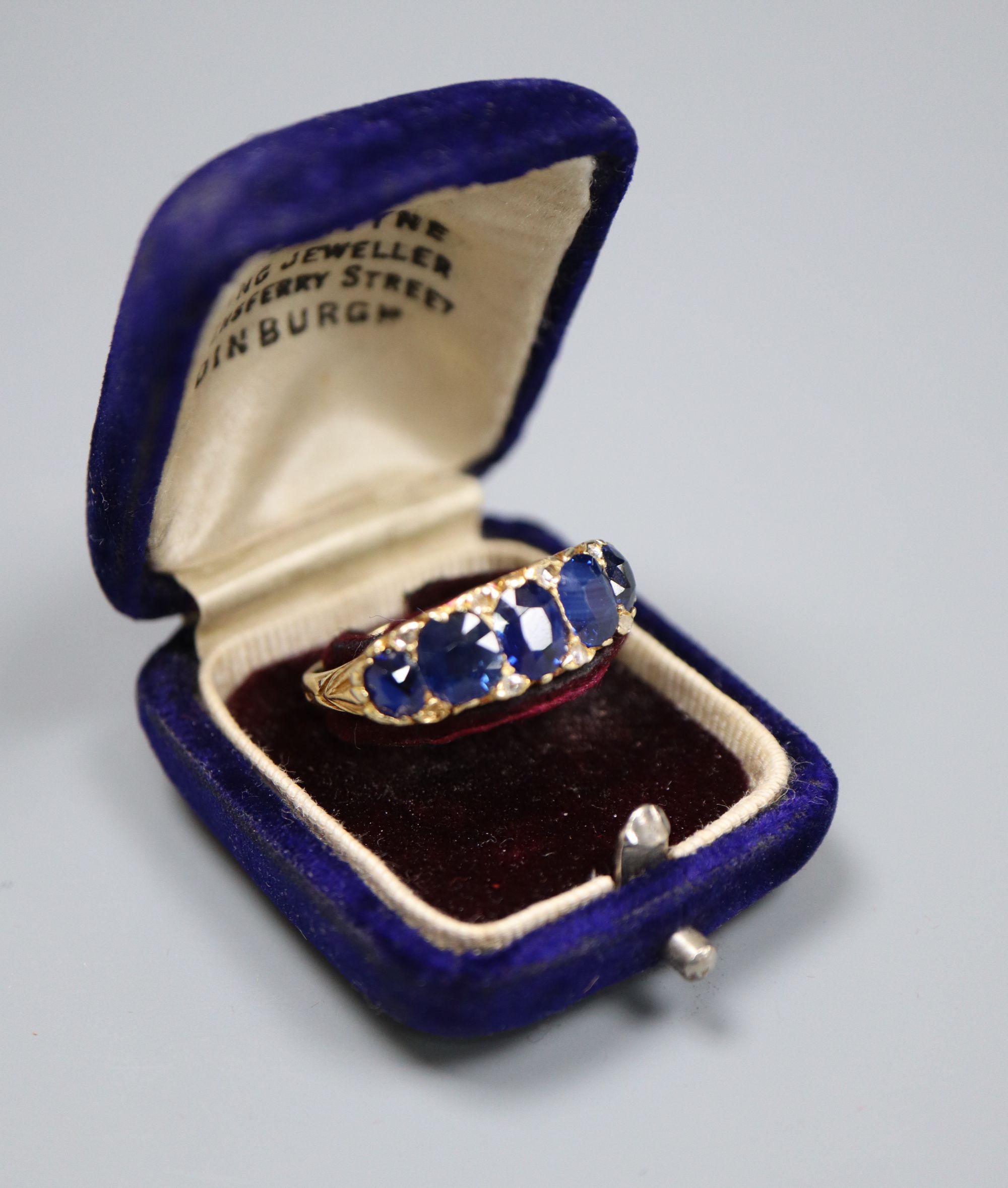 A George V 18ct gold and graduated five stone sapphire set half hoop ring, with diamond chip - Image 5 of 5