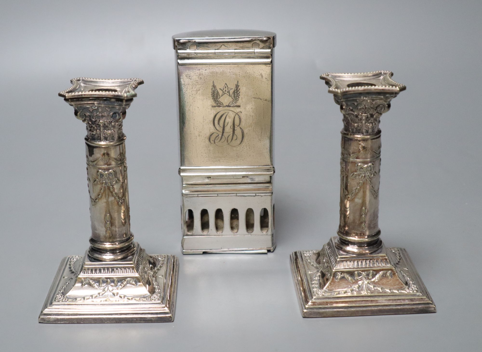 A pair of Victorian plated and embossed dwarf candlesticks and a Victorian plated pocket lamp,