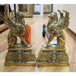 A pair of Victorian cast brass winged lion fire dogs, depth 53cm height 31cm