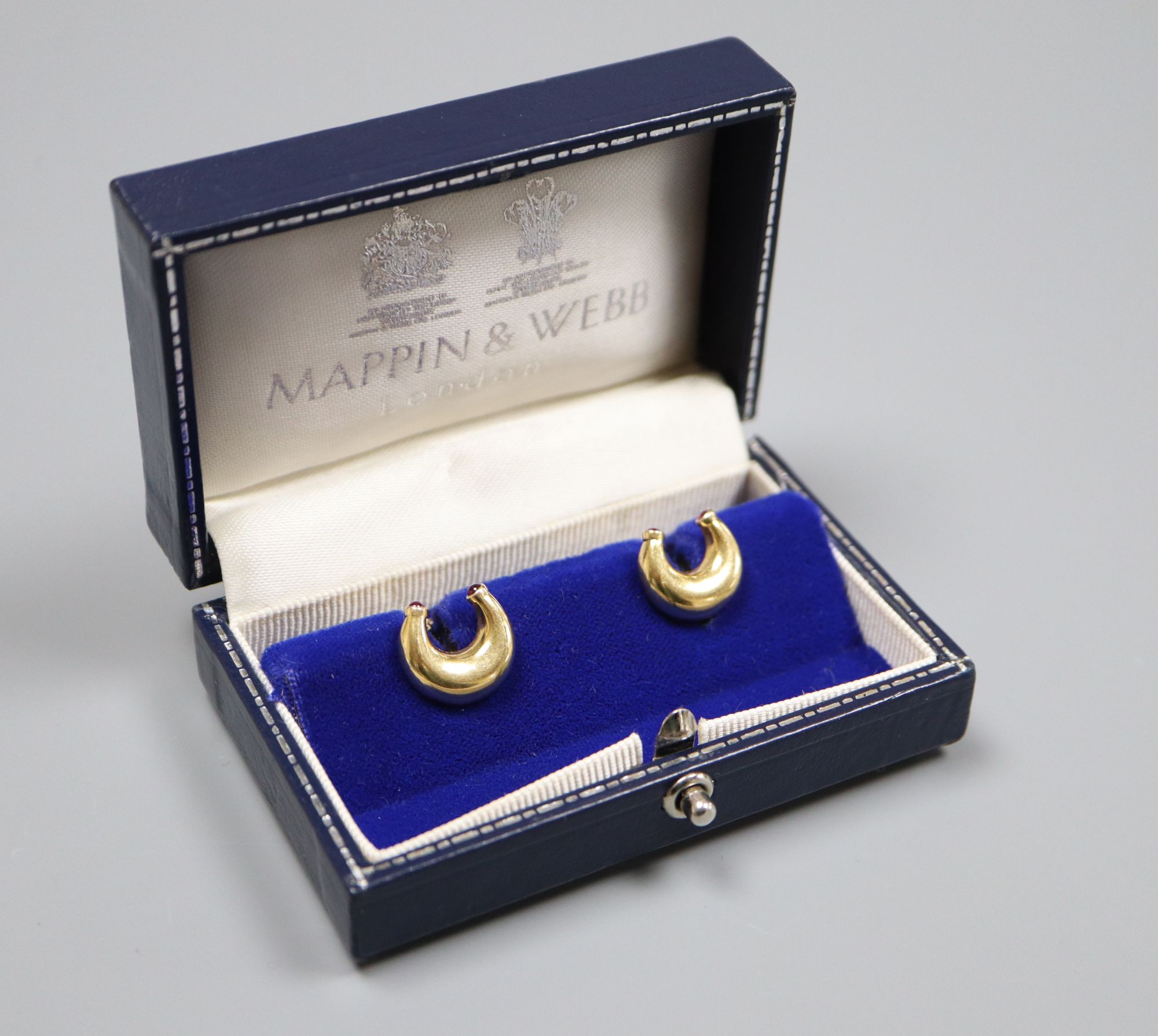 A pair of modern 18ct gold and ruby set horseshoe shaped cufflinks by Mappin & Webb, London, 1989,