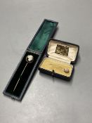 A cased early 20th century yellow metal and carved sardonyx set stick pin, 8cm and a similar 'shell'