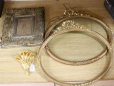 A pair of Victorian ornate gilt gesso oval picture frames, 50 x 55cm, a similar wall shelf and a