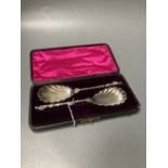 A cased pair of late Victorian silver serving spoons, with shell bowls and figural terminals,