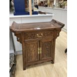 A Chinese carved hardwood side cabinet, fitted one long drawer over a pair of doors, width 70cm