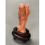 A Chinese carved coral figure of Shou Lao, on inlaid wooden stand, overall 81mm.