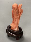 A Chinese carved coral figure of Shou Lao, on inlaid wooden stand, overall 81mm.