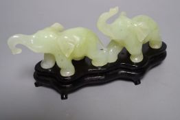 A carved bowenite jade group of two elephants, 16cm long with stand, boxed
