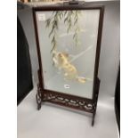 A Chinese carved hardwood framed table screen, the panel silk embroidered with a kitten at play,