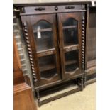 A 1920's oak two door glazed bookcase, width 92cm depth 30cm height 140cm