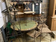 An iron framed circular tiled top table, a set of six iron framed chairs, with rope work seats and a