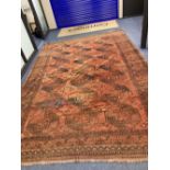 An antique Bokhara burgundy ground carpet, 400 x 280cm
