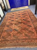 An antique Bokhara burgundy ground carpet, 400 x 280cm