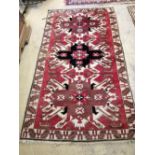 A Kazak red ground rug, 180 x 105cm