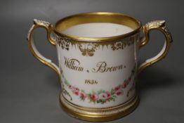An English porcelain two handled mug lavishly painted with flowers, inscribed verso William Brown