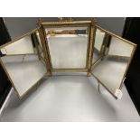 A gilt framed triptych mirror with faux ivory angelic panel and similar floral painted panel, height