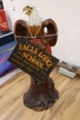 A carved and painted wood model of a Bald Eagle perched on a tree stump and a carved and painted