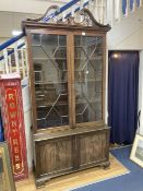 A George III style mahogany two door glass china display cabinet, with two panelled doors beneath,