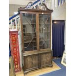 A George III style mahogany two door glass china display cabinet, with two panelled doors beneath,