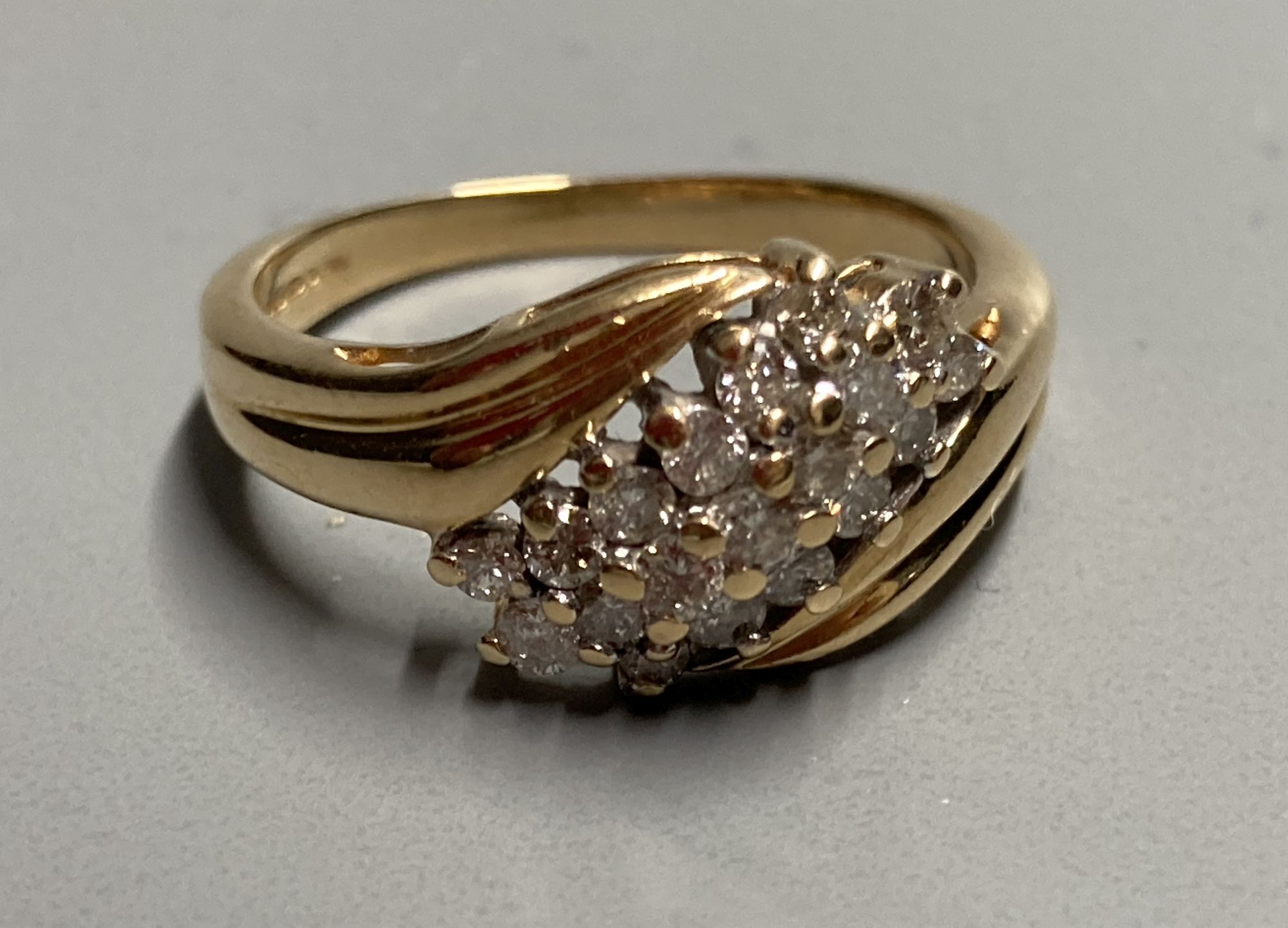 A modern 18ct gold and nineteen stone three stone three row diamond crossover ring, size N, gross