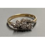 An 18ct and plat. illusion set three stone diamond crossover ring, size O/P, gross 3 grams.